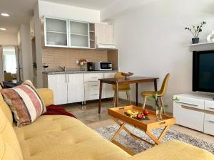 ein Wohnzimmer mit einem Sofa und einem Tisch in der Unterkunft Яркая студия ФРИДА КАЛО в центре города Алматы in Almaty