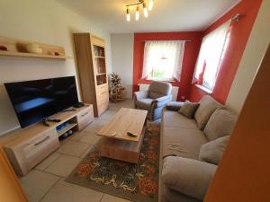 a living room with a couch and a flat screen tv at Ferienhaus Margarete in Dankerode