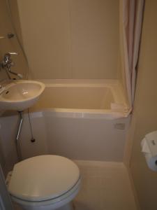 een badkamer met een toilet, een wastafel en een bad bij Hotel Select Inn Shikoku Chuo in Shikokuchuo