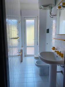 a white bathroom with a sink and a toilet at Casamare San Giorgio 2 in Sciacca