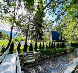a garden with a stone path and trees and a fence at Swiss House Sarajevo in Trnovo +22 photos