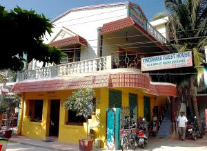 un edificio giallo con balcone su una strada di Vinodhara Guest House a Mamallapuram