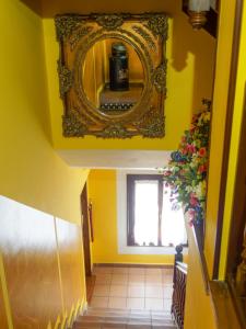 a yellow hallway with a mirror and a vase of flowers at Hostería Miguel Angel in Santillana del Mar