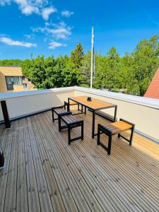 a deck with a table and benches on a roof at Hotel Vesiroos in Pärnu