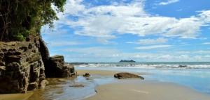 a beach with rocks and the ocean on a cloudy day at Casita El Sonido de las Aves in Uvita +11 photos