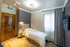 a small bedroom with a bed and a window at Mr.Liao Hotel in Himberg