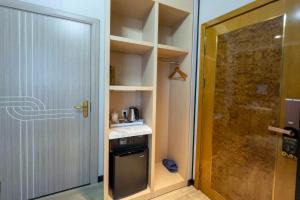 uma pequena cozinha com uma porta e um fogão num quarto em Mr.Liao Hotel em Himberg
