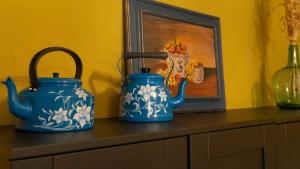 dos jarrones azules sentados en un tocador con una foto en El Balcón de Sotero y María, en Prádena de Atienza
