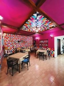 a restaurant with tables and chairs and a colorful ceiling at Pensiunea Victoria in Râşnov