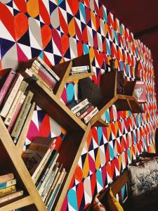 a book shelf with books and a colorful wall at Pensiunea Victoria in Râşnov