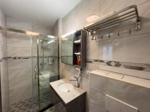 a bathroom with a sink and a glass shower at Mr.Liao Hotel in Himberg