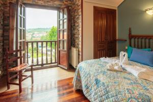 a bedroom with a bed and a balcony at Hostería Miguel Angel in Santillana del Mar