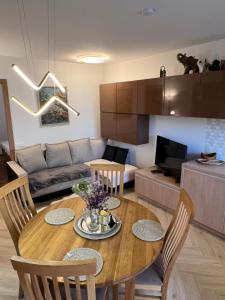 a kitchen and living room with a wooden table and chairs at Ruta 15 in Nida