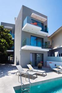 a building with a swimming pool next to a house at Azul Apartments in Nydri