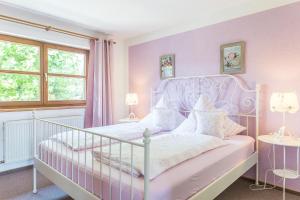 a pink bedroom with a white bed and two lamps at Gästehaus Chalet-Perle in Bad Füssing