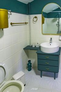 a bathroom with a sink and a toilet and a mirror at Wine Reflections Apartment near Nafplio in Néa Kíos