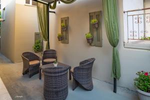 patio z krzesłami, stołem i oknem w obiekcie Wine Reflections Apartment near Nafplio w mieście Nea Kios