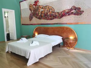 a bedroom with two beds and a painting on the wall at Speciale Tarshito Guesthouse Bari in Bari