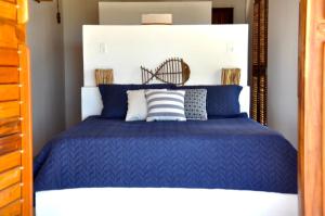 a bedroom with a blue bed with a white headboard at Casa Mandakarú in Icapuí