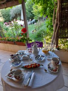 uma mesa com uma toalha de mesa branca com comida em Aux Glycines em Marcilly-Ogny