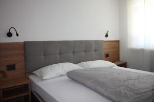 een bed met een groot hoofdeinde en 2 kussens bij CASA IBEX - Piscina - Sauna - Baby Club in Cavalese