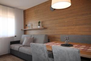 a dining room with a couch and a table at CASA IBEX - Residence Veronza con piscina, Dolomiti Affitti in Cavalese +37 photos