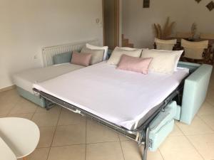 a bed with pink pillows on it in a room at Villa Nostalgia in Skala Potamias +19 photos
