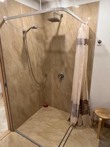 a shower in a bathroom with a shower curtain at Ruta 15 in Nida +15 photos