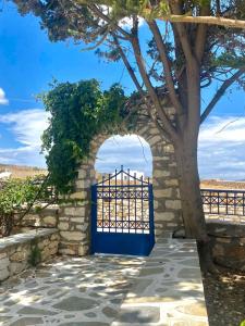 an archway with a blue gate next to a tree at Gaia home in Prodromos Paros