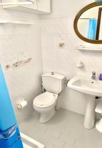 a white bathroom with a toilet and a sink at Gaia home in Prodromos Paros