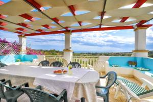 a patio with a table and chairs with a view at Appartamento Casa dell'Olivo in Marina di Pescoluse