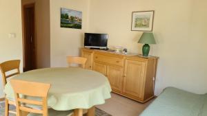 a room with a table and a tv on a cabinet at Au pied du Markstein in Oderen