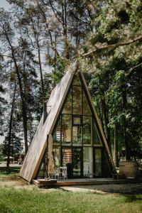 a small house with glass windows and a tree at Trikampis MIŠKO NAMELIS Druskininkų centre in Druskininkai