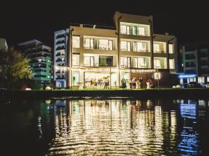 a building at night next to a body of water at Poeme Mamaia Retreat in Mamaia