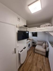 a small room with a bunk bed and a couch at Cosy Studio near Champs-Elysées - Arc de Triomphe in Paris
