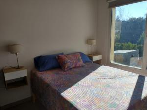 a bedroom with a bed and a large window at PeHache Bariloche in San Carlos de Bariloche