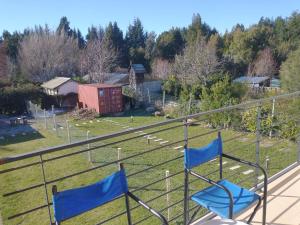 two chairs on a balcony with a view of a yard at PeHache Bariloche in San Carlos de Bariloche