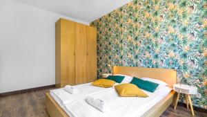 łóżko z żółtymi i zielonymi poduszkami w sypialni w obiekcie Alzacja w mieście Gdynia