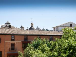 Apartamento Lomeña في غرناطة: مبنى برتقالي مع الأشجار في المقدمة