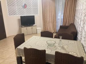 comedor con mesa y TV en Апартамент Анастасия Аполон 6, en Ravda