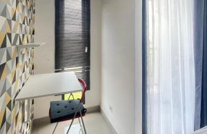 a room with a table and a chair and a window at Apartemen Sayana Harapan Indah by Cheapinn in Tambun-lobangbuaja
