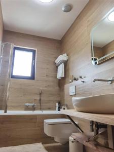 a bathroom with a sink and a tub and a toilet at yipin villa in Prague