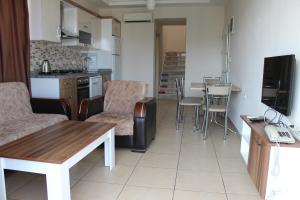 eine Küche und ein Wohnzimmer mit einem Tisch und Stühlen in der Unterkunft Tebriz Apart in Kemer