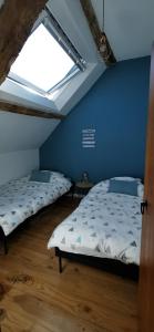 2 Betten in einem Zimmer mit Fenster in der Unterkunft gîte Les Châtaigniers entre terre et mer in Pleucadeuc