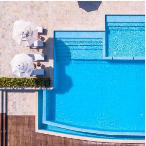 una vista aérea de una piscina con sombrillas y sillas en Apartamento Acceso Directo a la piscina A-108, A-120, A-117 y B-136, en Punta Cana
