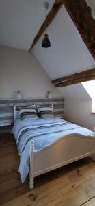 ein Schlafzimmer mit einem weißen Bett im Dachgeschoss in der Unterkunft gîte Les Châtaigniers entre terre et mer in Pleucadeuc