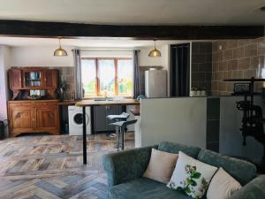 a living room with a couch and a kitchen at L'ancienne Forge in Chéronnac