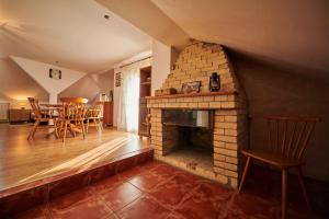 sala de estar con chimenea de ladrillo y mesa en Vila Ţara Haţegului en Haţeg