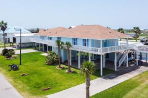 uma vista aérea de uma casa azul com palmeiras em Bayside Bliss em Crystal Beach