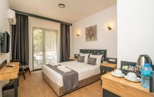 una camera d'albergo con letto e scrivania di Marmaris Kensington Green a Marmaris